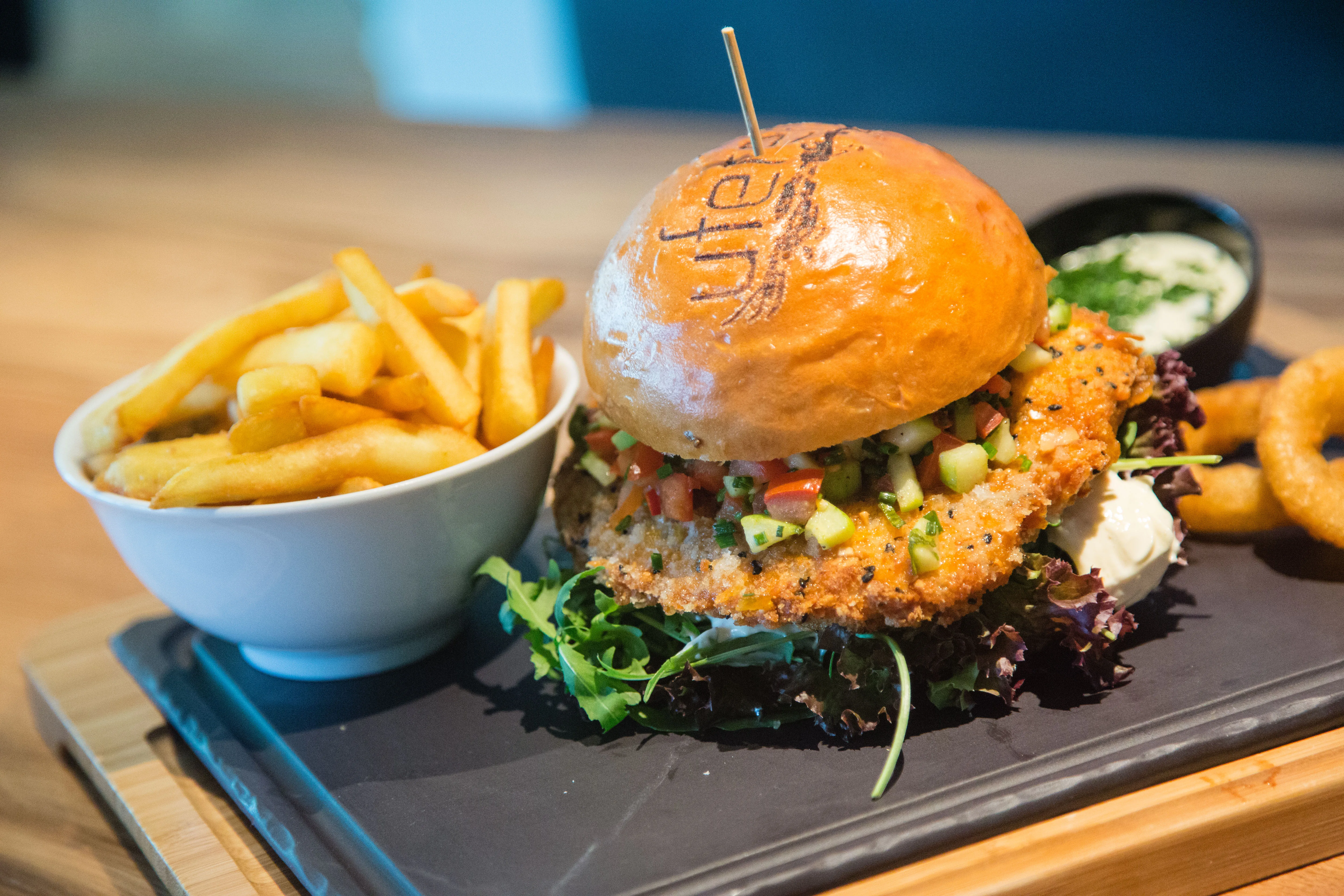 Ein knuspriger Burger mit frischem Gemüse und Pommes frites.