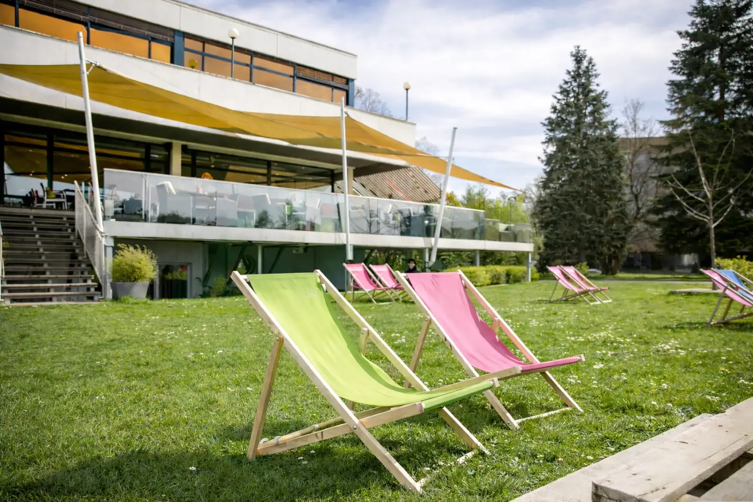 Bunte Liegestühle auf der Wiese vor dem Restaurant im Sommer